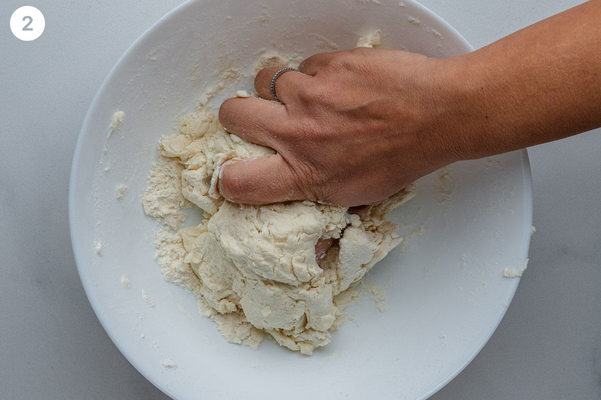 Hand combining the dough in a bowl