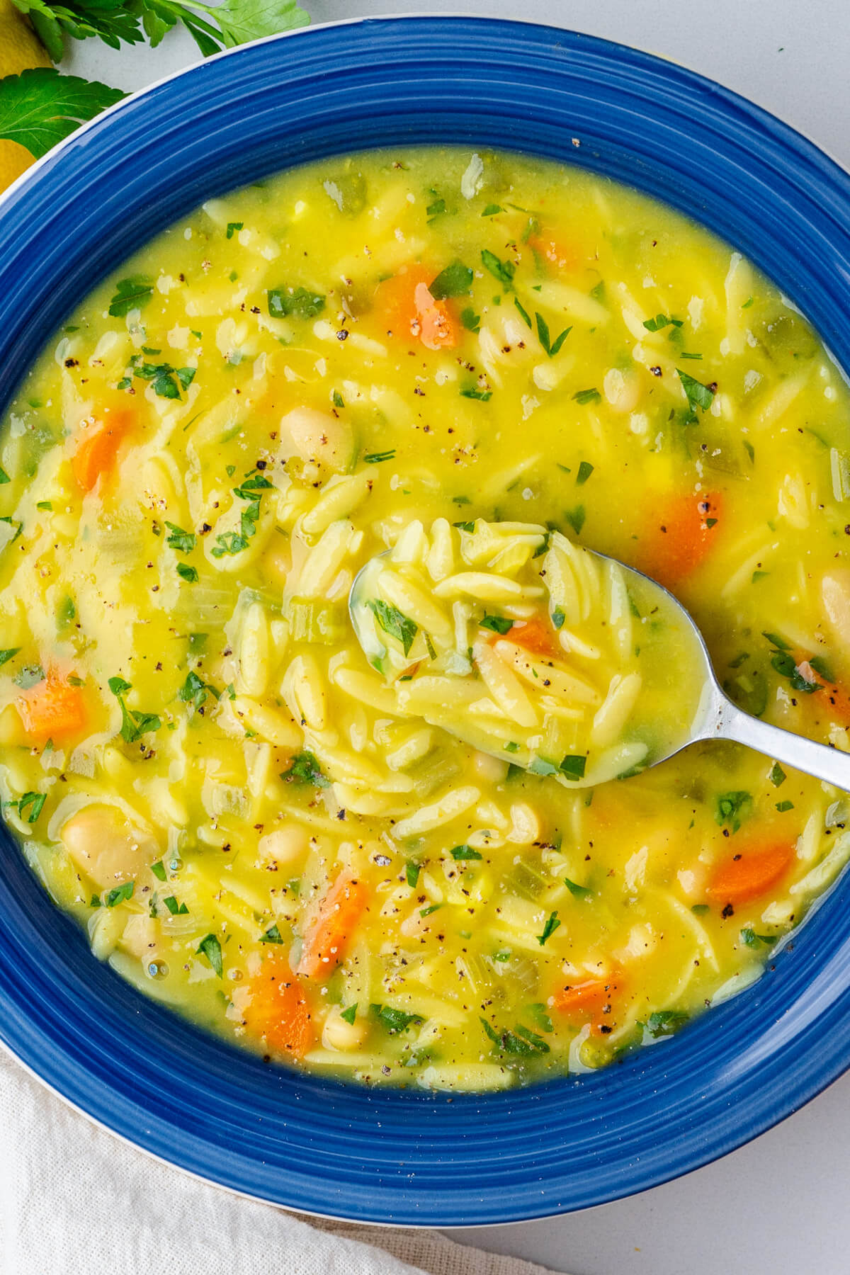 Lemon orzo soup with spoon coming out of bowl