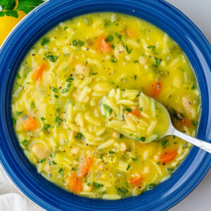 Spoon in a bowl of lemon orzo soup