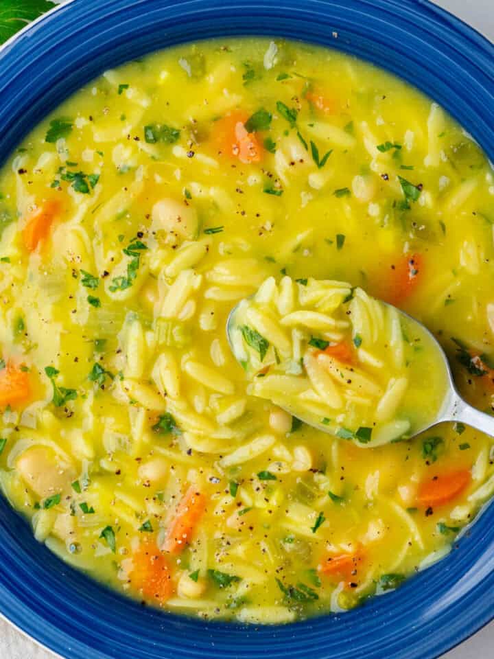 Spoon in a bowl of lemon orzo soup