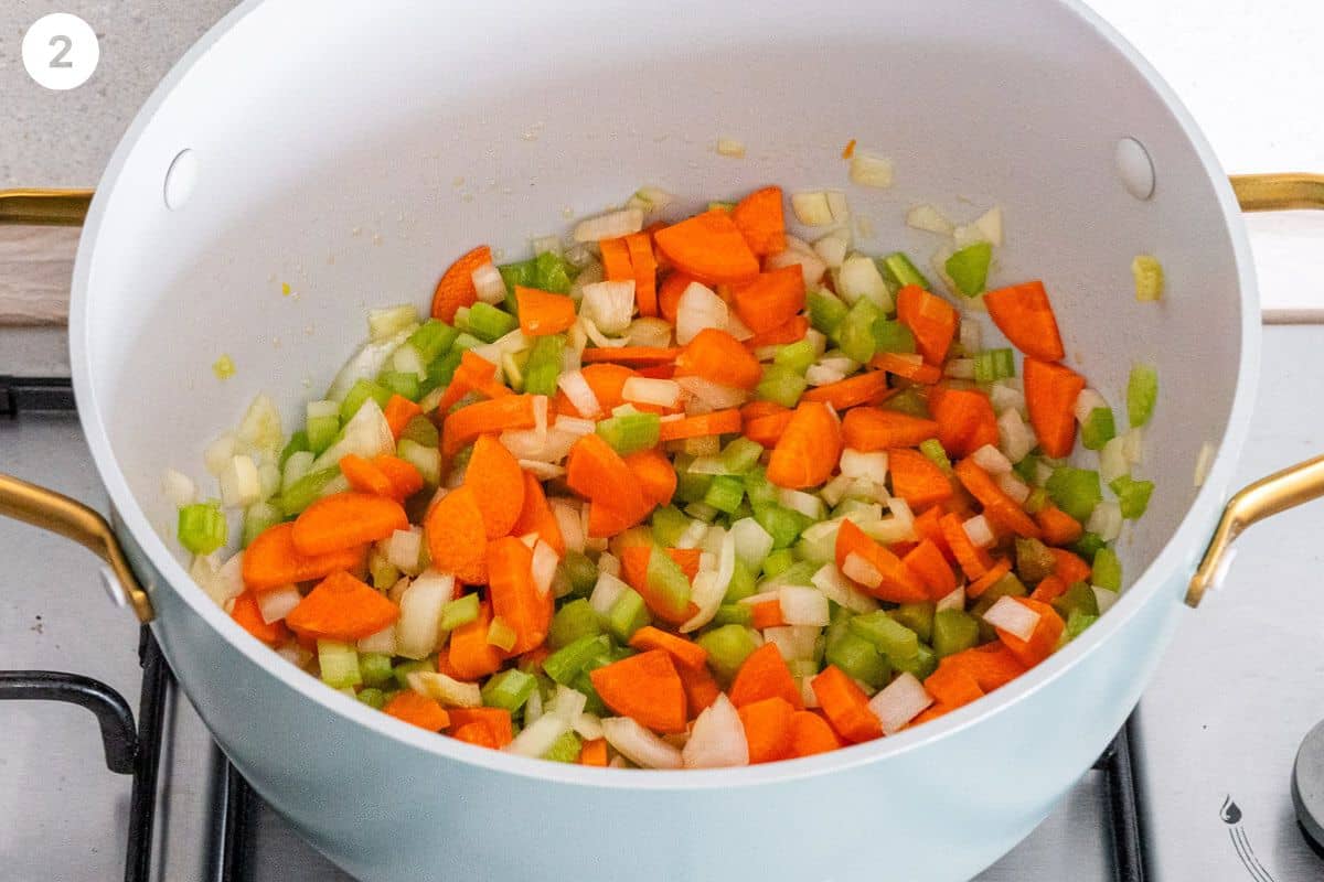 Vegetables being sautéed in a large pot