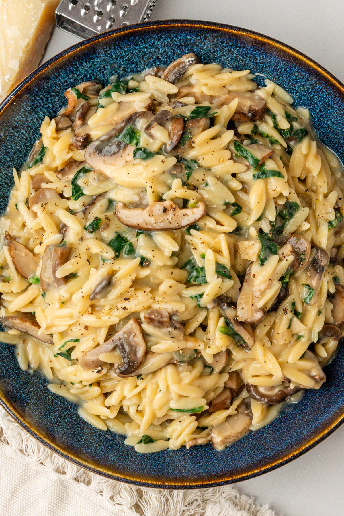 Bowl of orzo pasta with black pepper and parmesan cheese