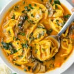 Tortellini soup in a bowl with a spoon