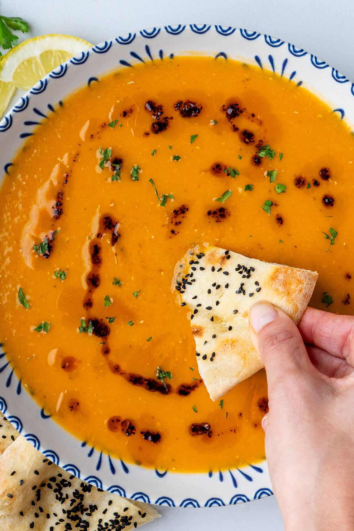 Turkish bread being dipped into lentil soup