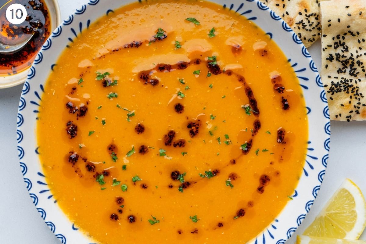 Final soup served in a bowl with aleppo pepper oil and fresh parsley