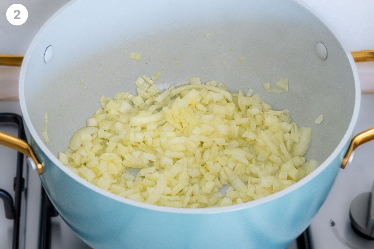 Onions being sautéed in a large pot