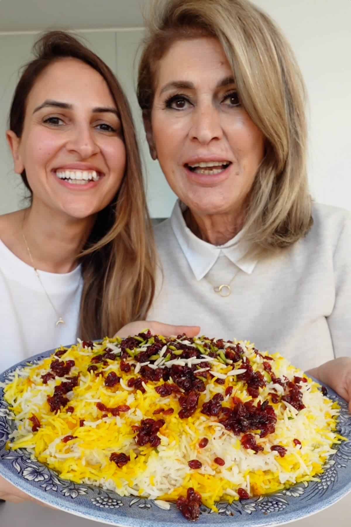 Ayeh and Mum holding a large plate of zereshk polo