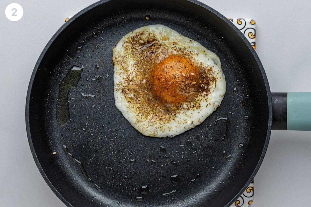 Egg being fried on a pan seasoned with zaatar