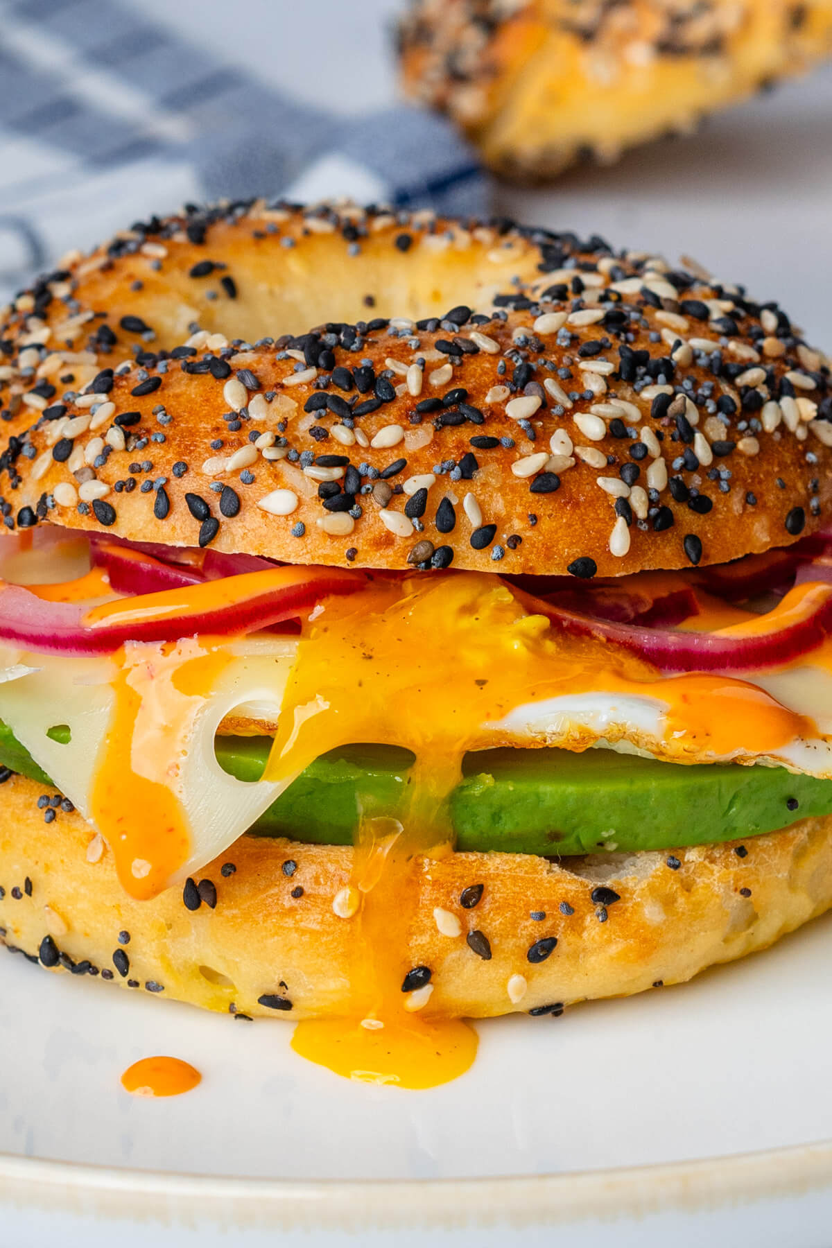 Breakfast bagels with oozy egg, pickled onions, avocado and cheese