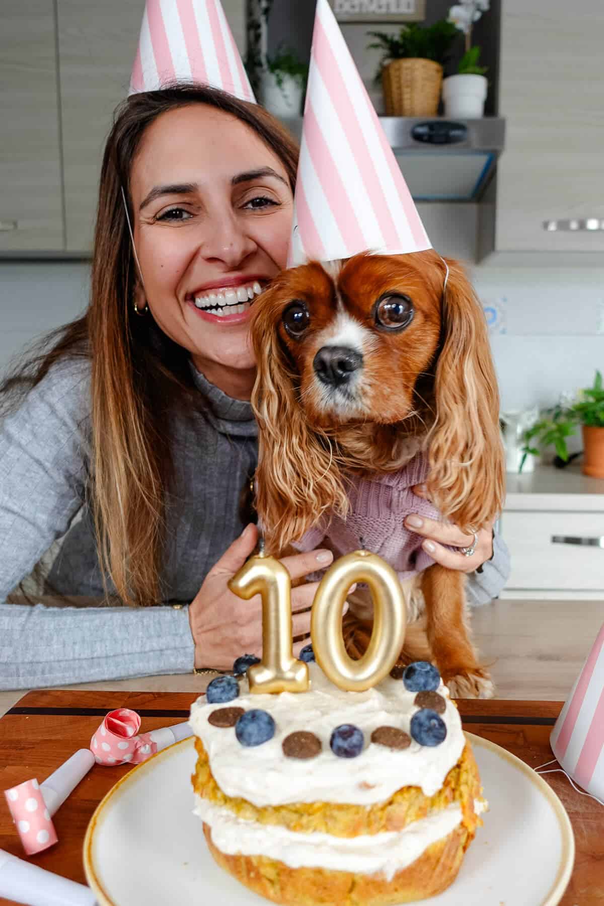 Ayeh and Coco posing behind a dog birthday cake