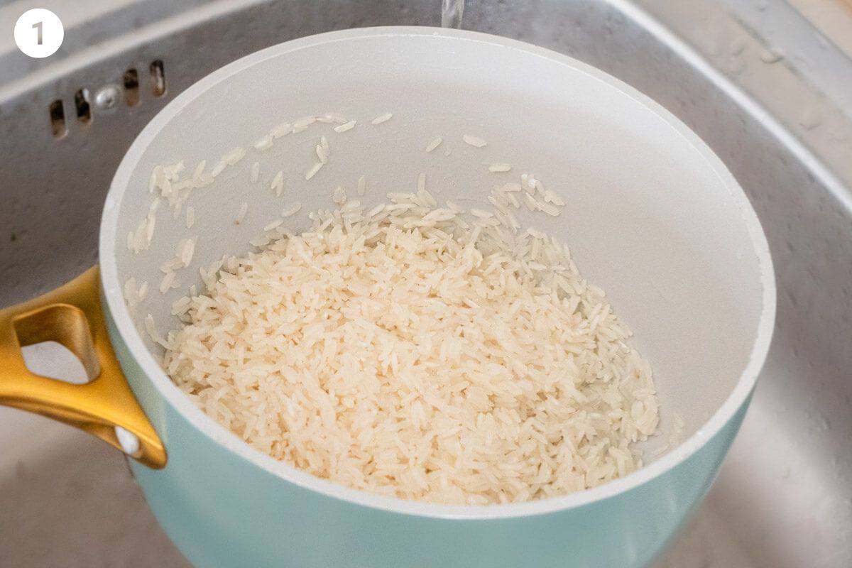 Rice in a pot being washed in water