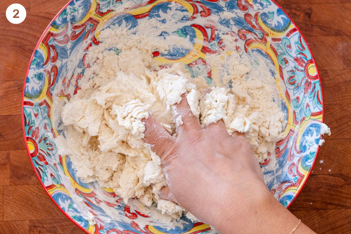 Hand combining yogurt and dough in a bowl