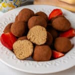 Tiramisu truffles on a plate with a piece cut in half