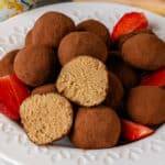 Tiramisu truffles on a plate with a piece cut in half