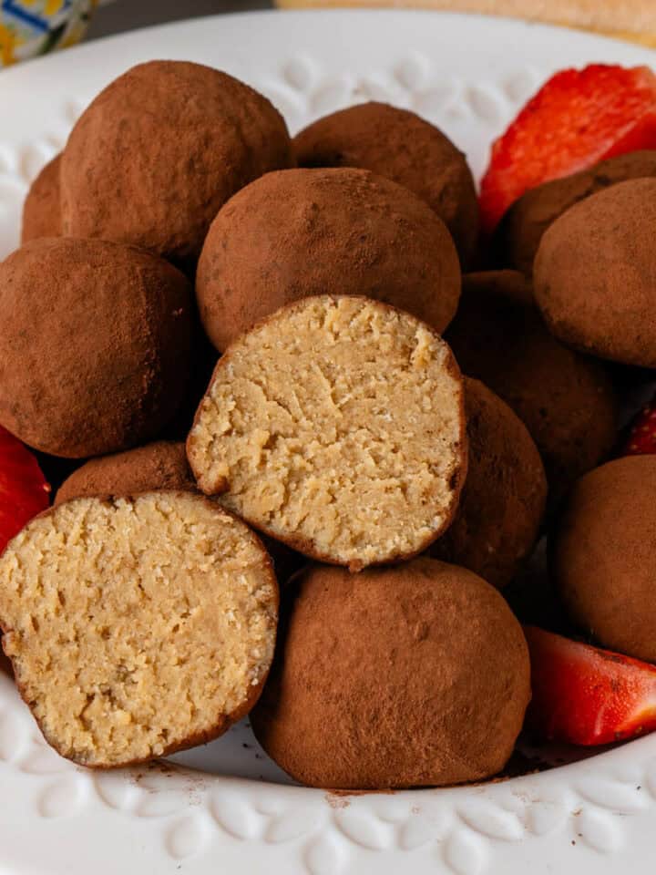 Tiramisu truffles on a plate with a piece cut in half