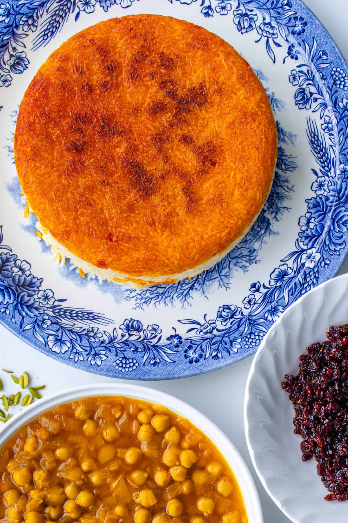 Plates of Persian rice with saffron tahdig, chickpea stew and barberries