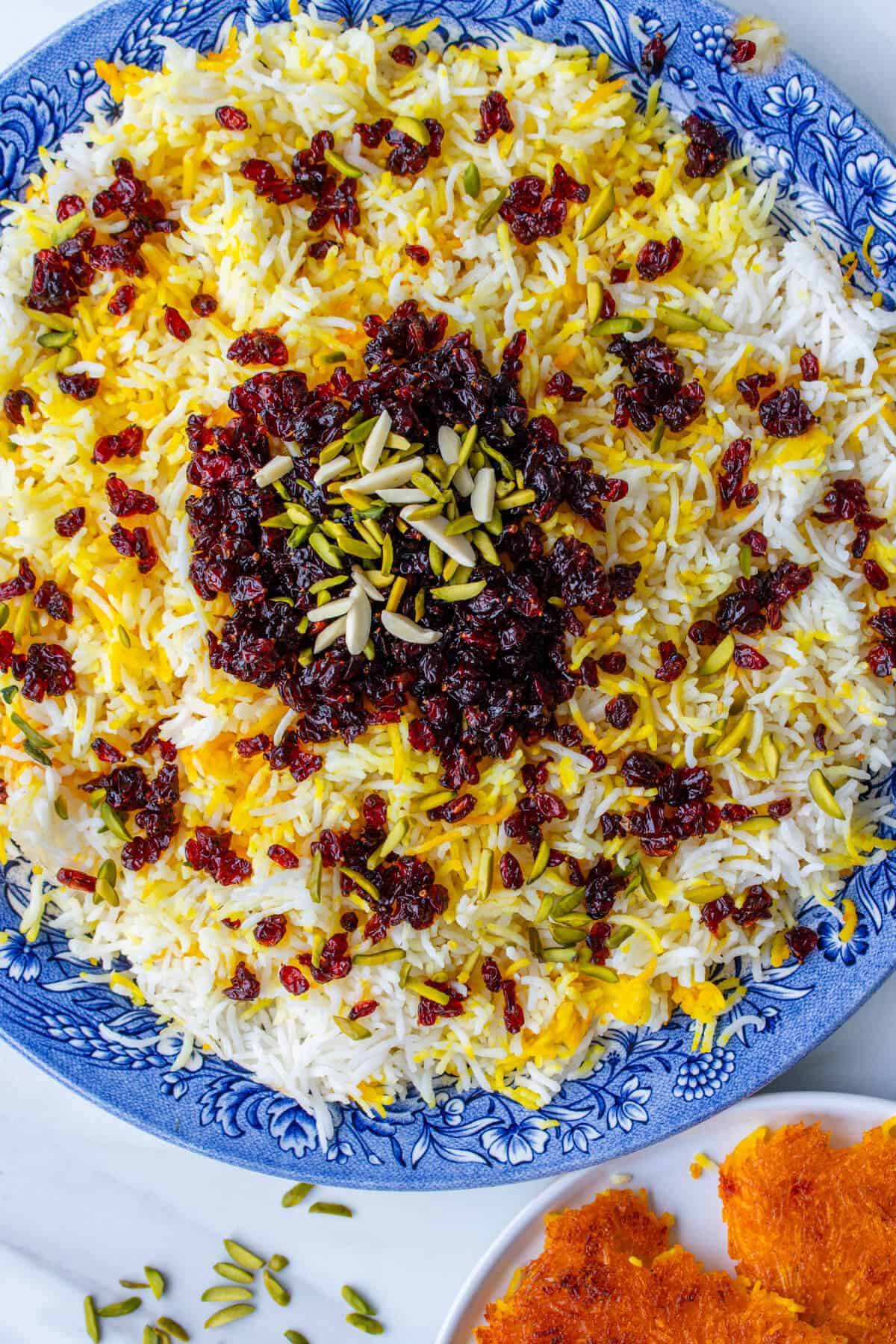 Zereshk Polo rice served on a large plate with tahdig on the side