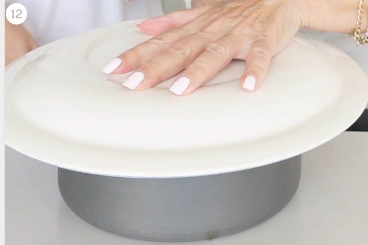 Plate placed on top of rice pot ready to flip upside down