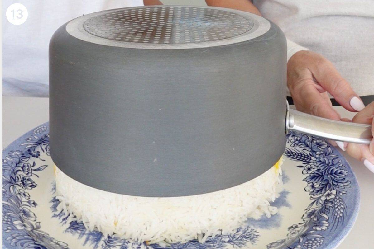 Pot being lifted to reveal cooked rice