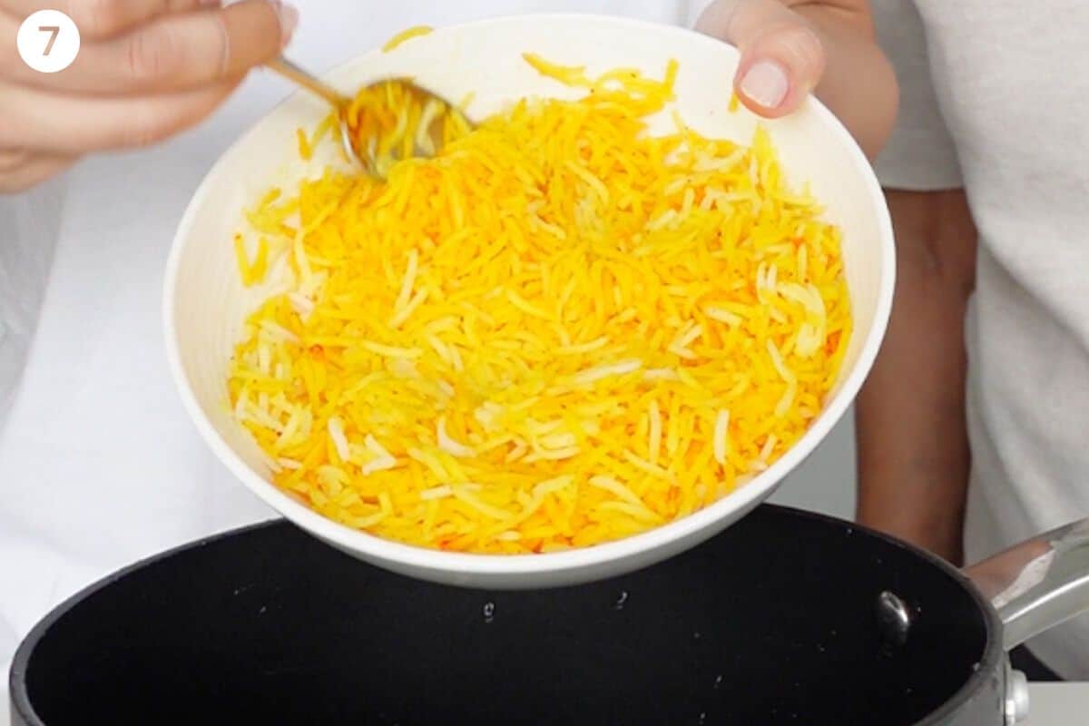 Saffron rice added to bottom of pot with oil