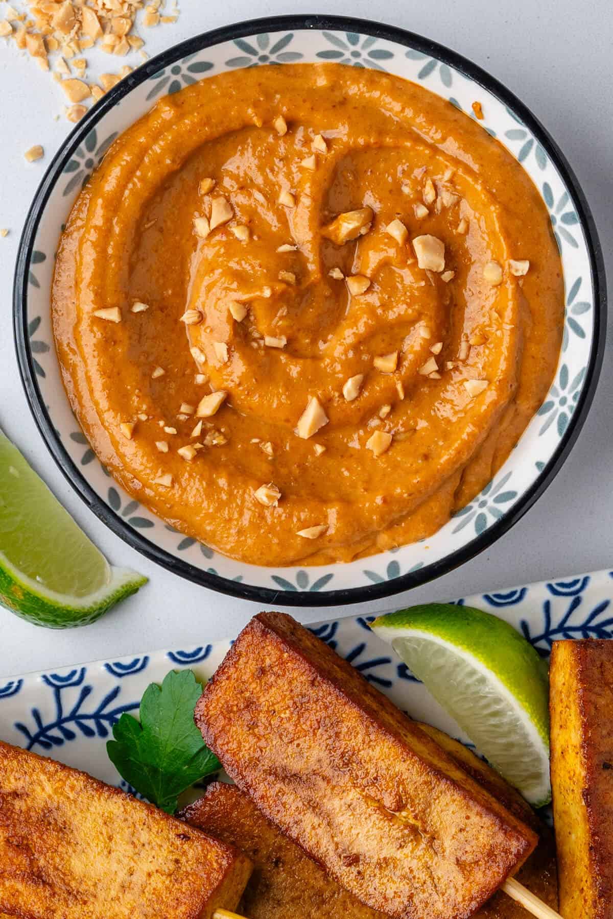 Satay sauce served in a small ramekin with tofu satay on the side