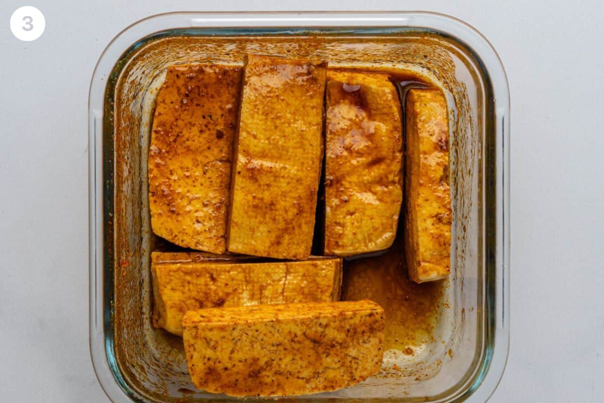 Pieces of tofu placed into marinade