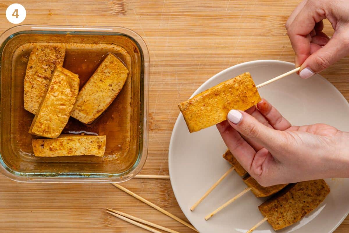 Sticks being placed into tofu to make skewers