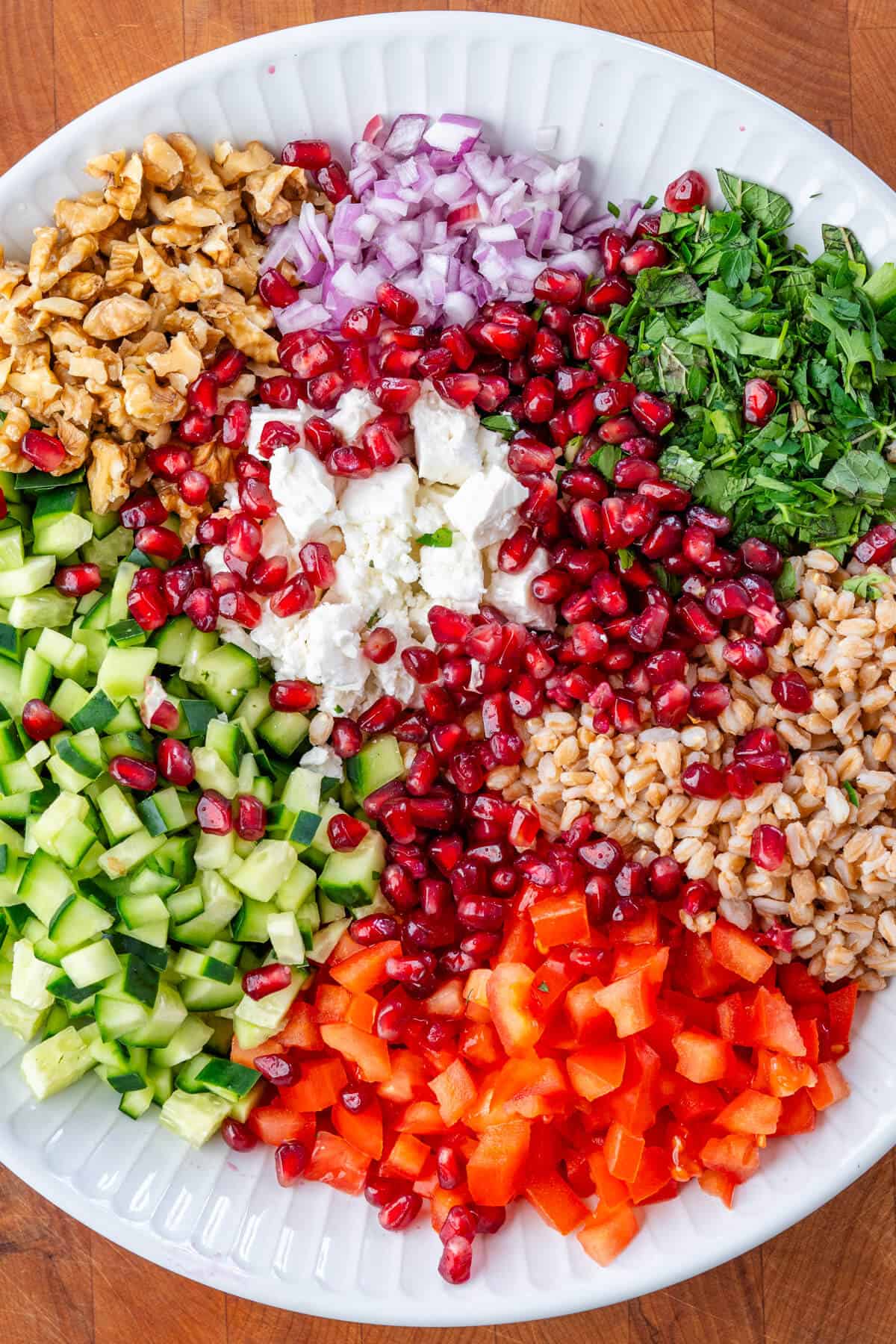 Farro salad ingredients in a bowl before being mixed