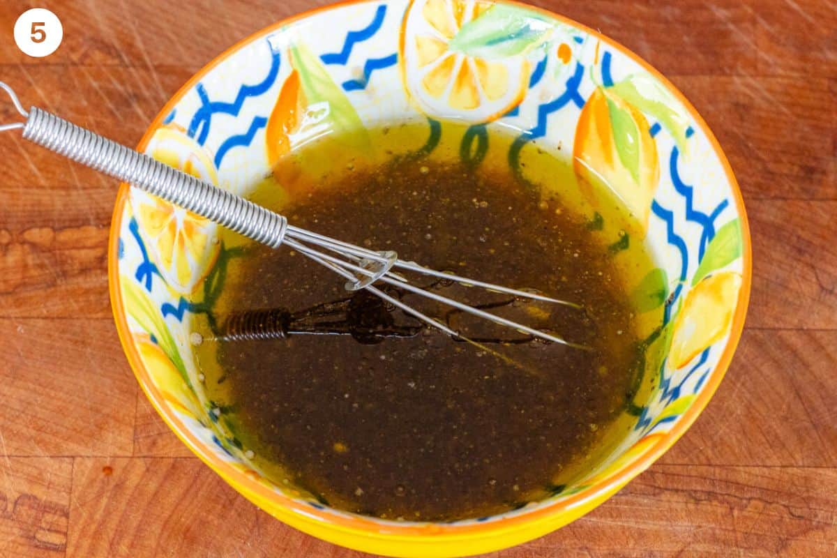 Salad dressing in a small bowl with a whisk