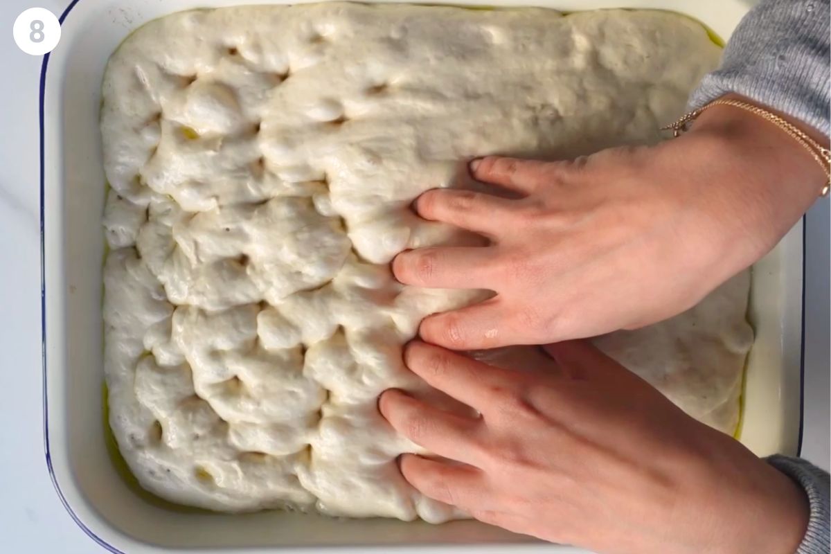 Hands dimpling the dough