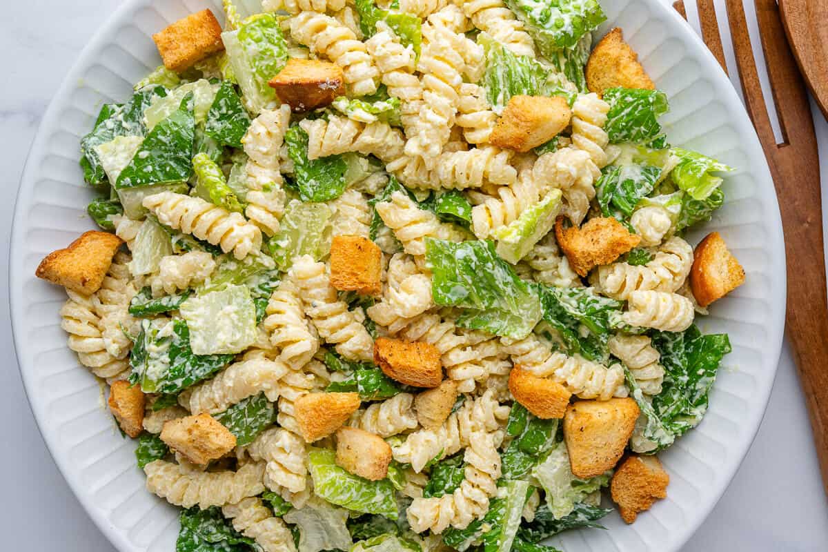 Caesar pasta salad served in a large bowl top with croutons