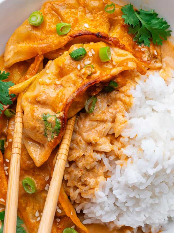 Dumpling bake with chopsticks picking up a dumpling in a bowl with rice