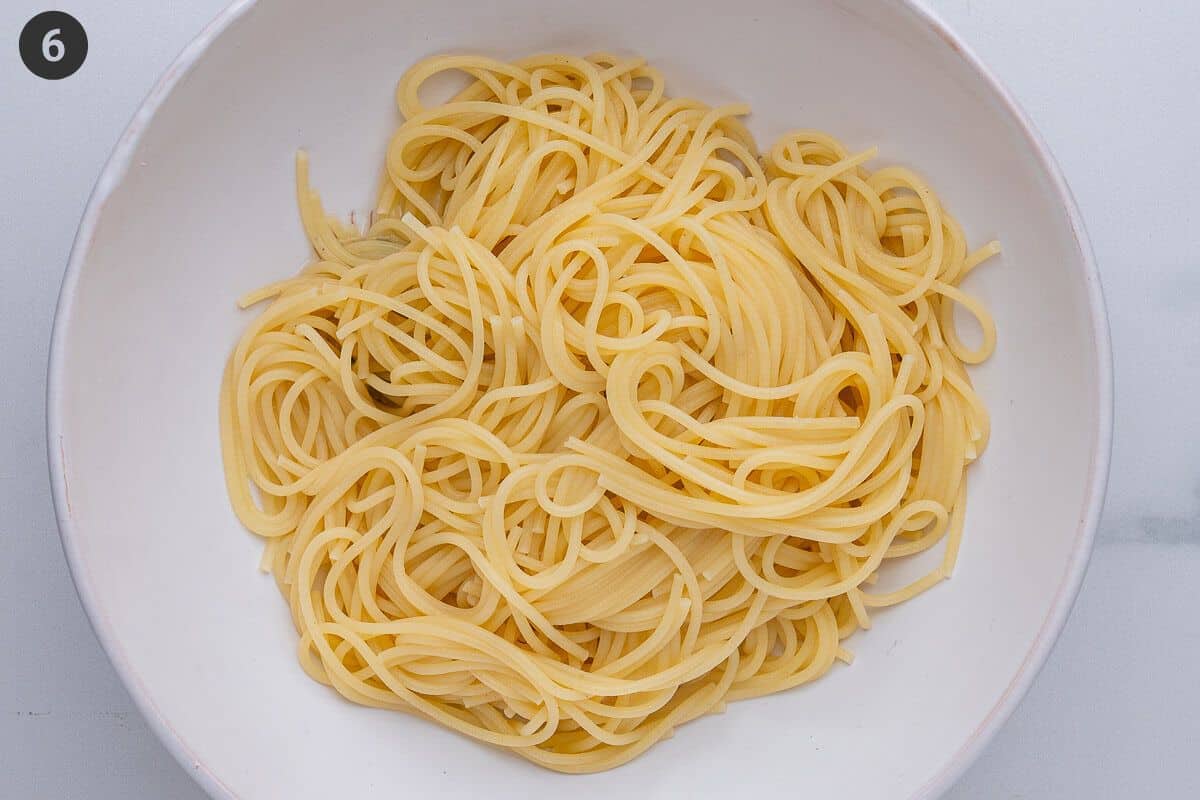 Pasta added to a bowl with some pasta water