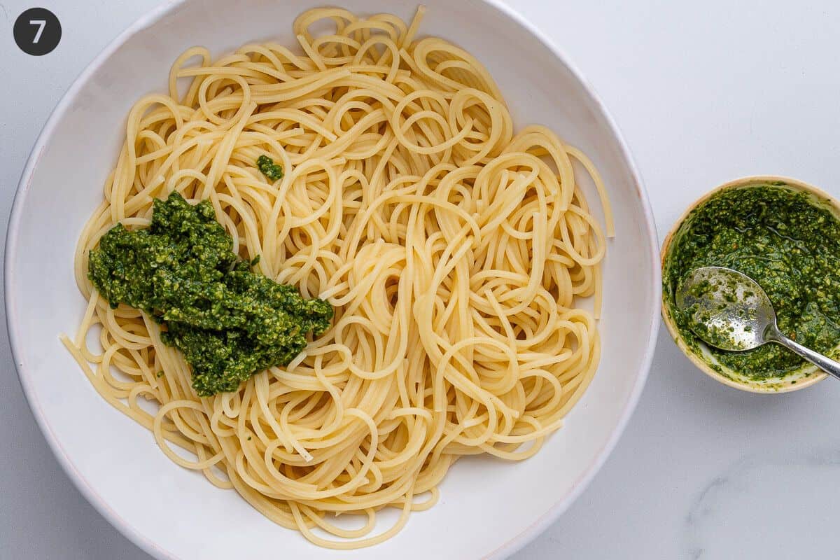 Pesto added to pasta in a bowl