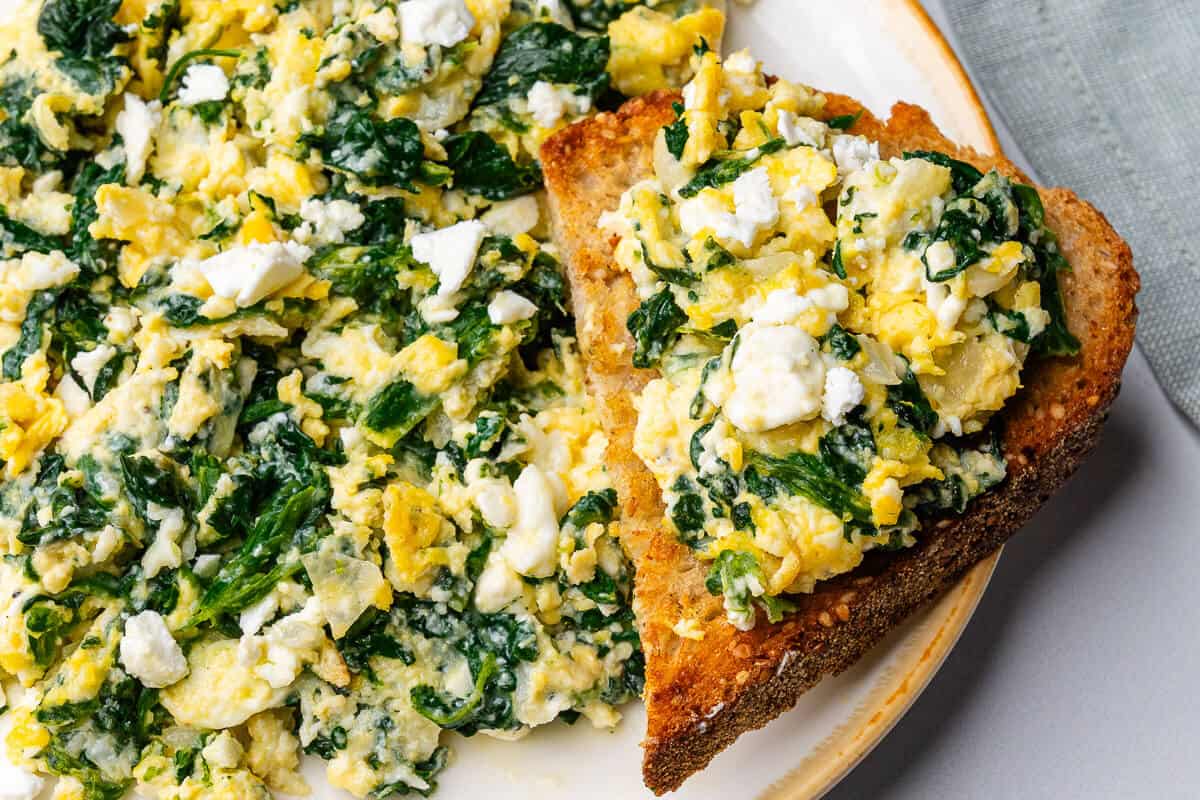 Spinach scrambled eggs on a plate with toast