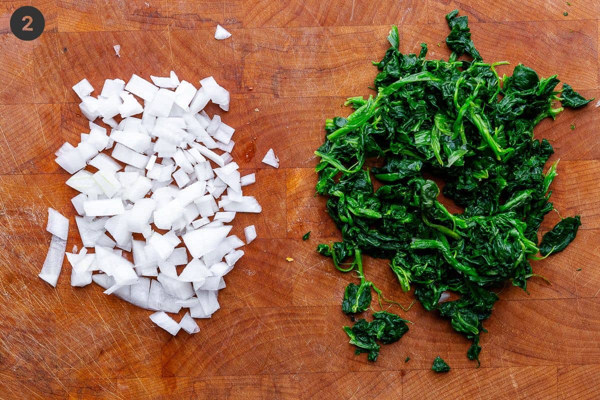 Spinach and onion chopped on a cutting board