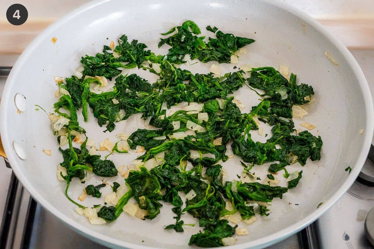 Spinach added to onion in a pan