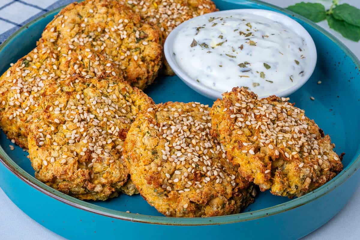 Chickpea fritters on a plate with Greek yogurt sauce on the side