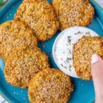 Chickpea fritters with a fritter being dipped into a Greek yogurt sauce
