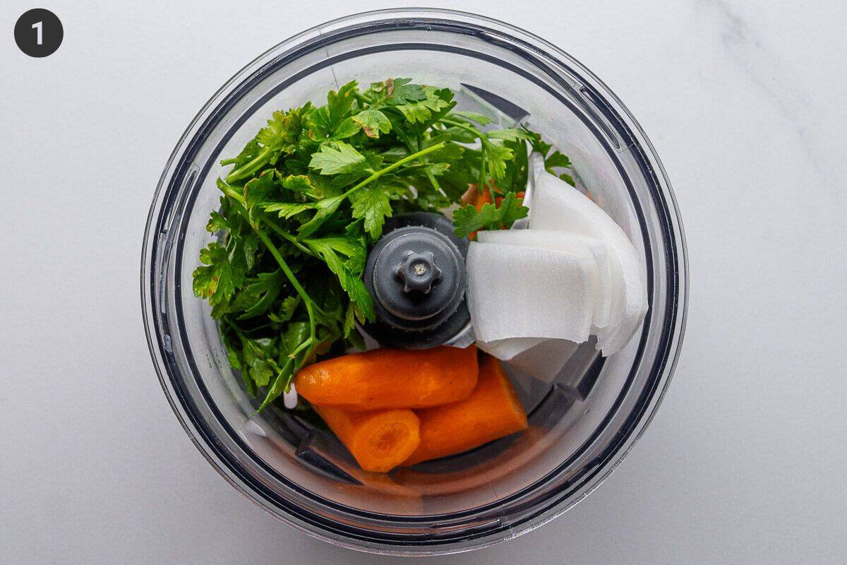 Parsley, onion and carrots in a blender before being blended