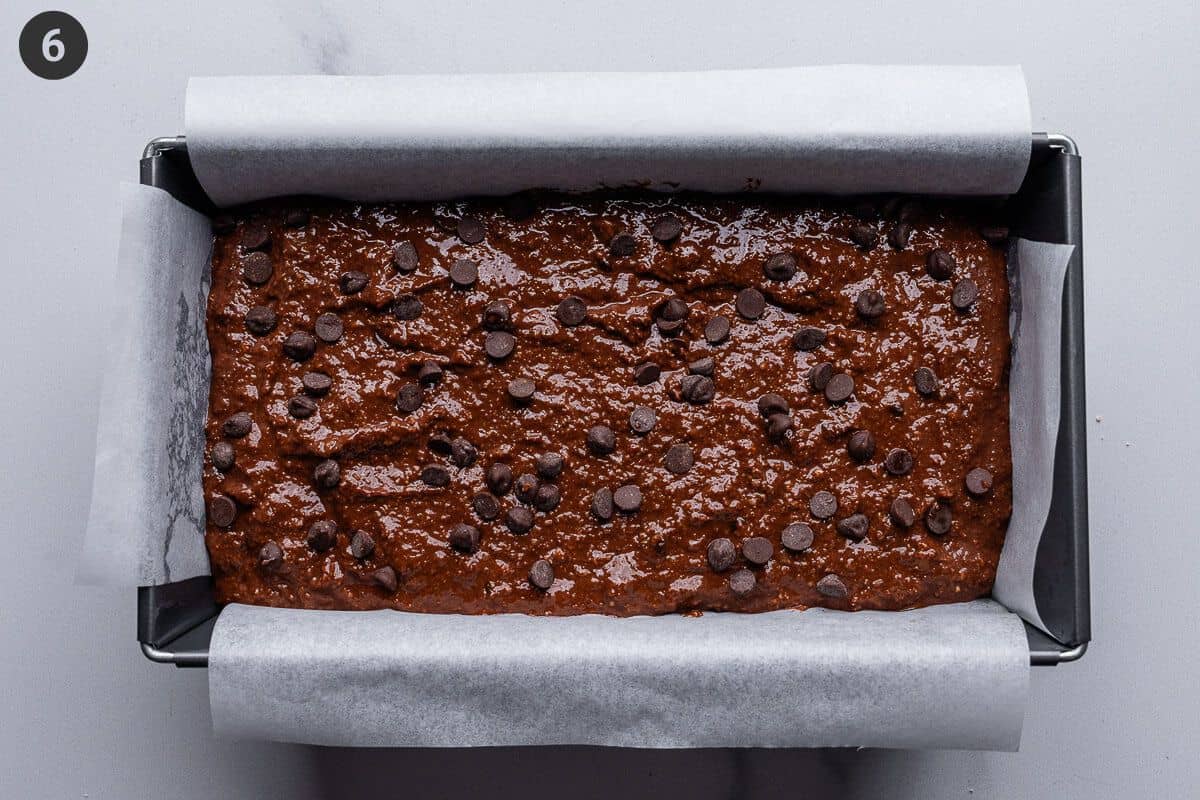 Batter placed in a loaf tin and topped with mini choc chips