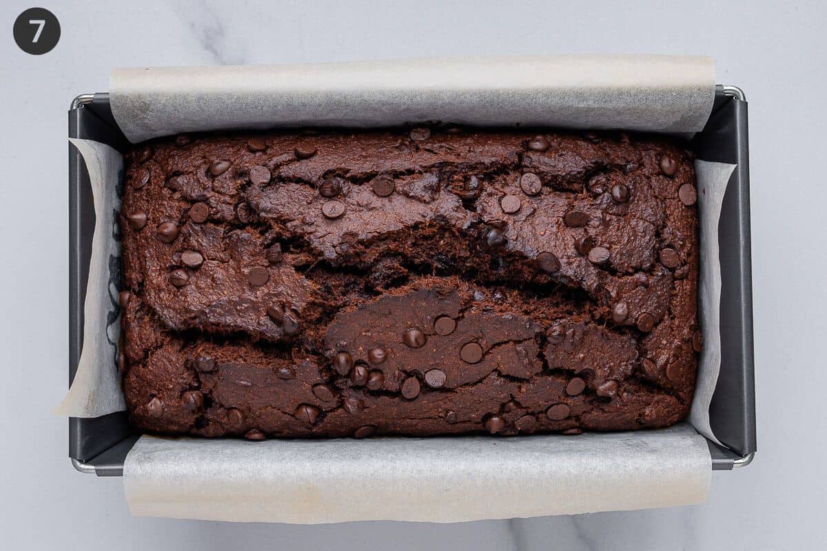 Bread resting in loaf tin out after coming out of the oven