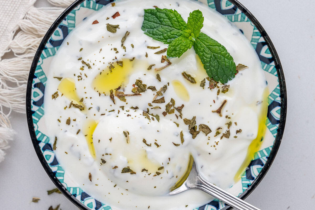 Greek Yogurt Sauce with mint on top and spoon inside