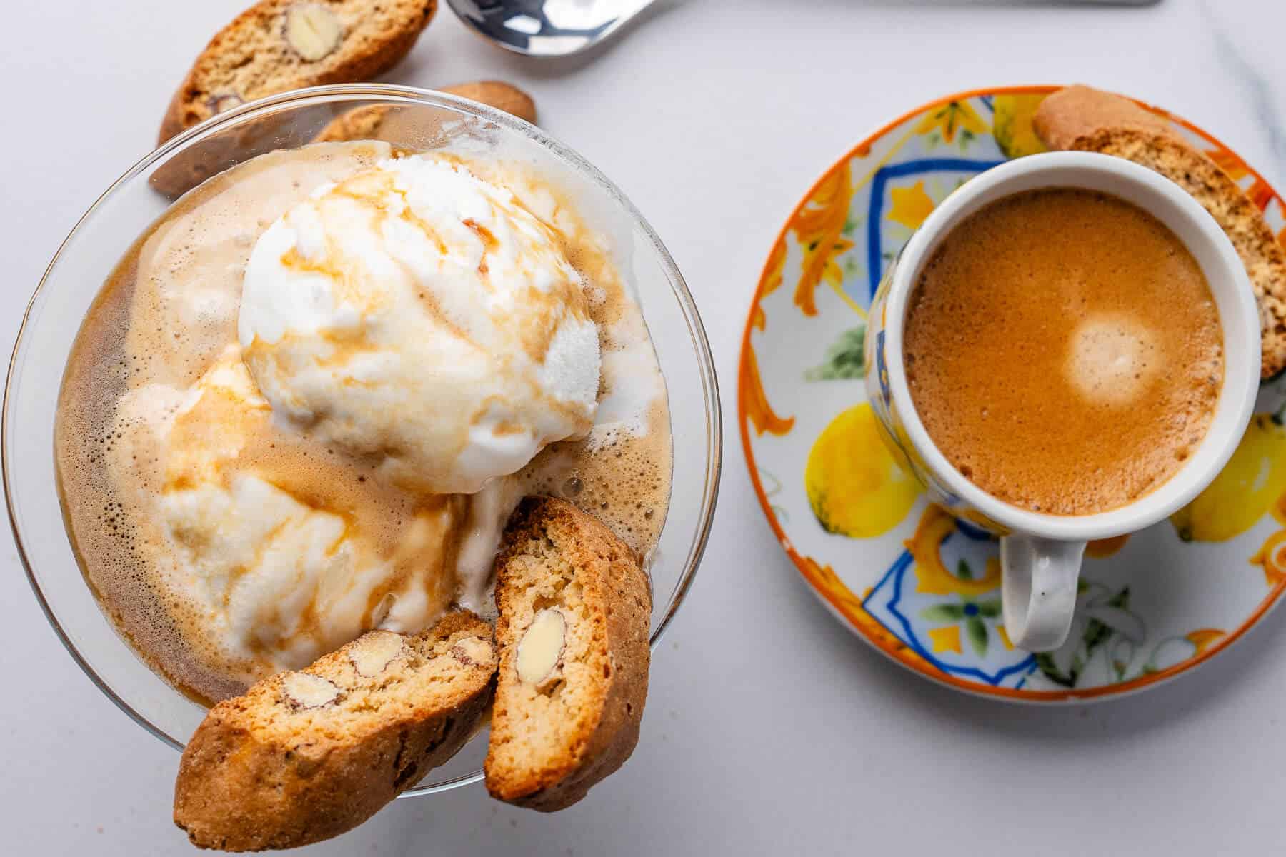 Glass cup of affogato with biscotti and coffee cup on the side