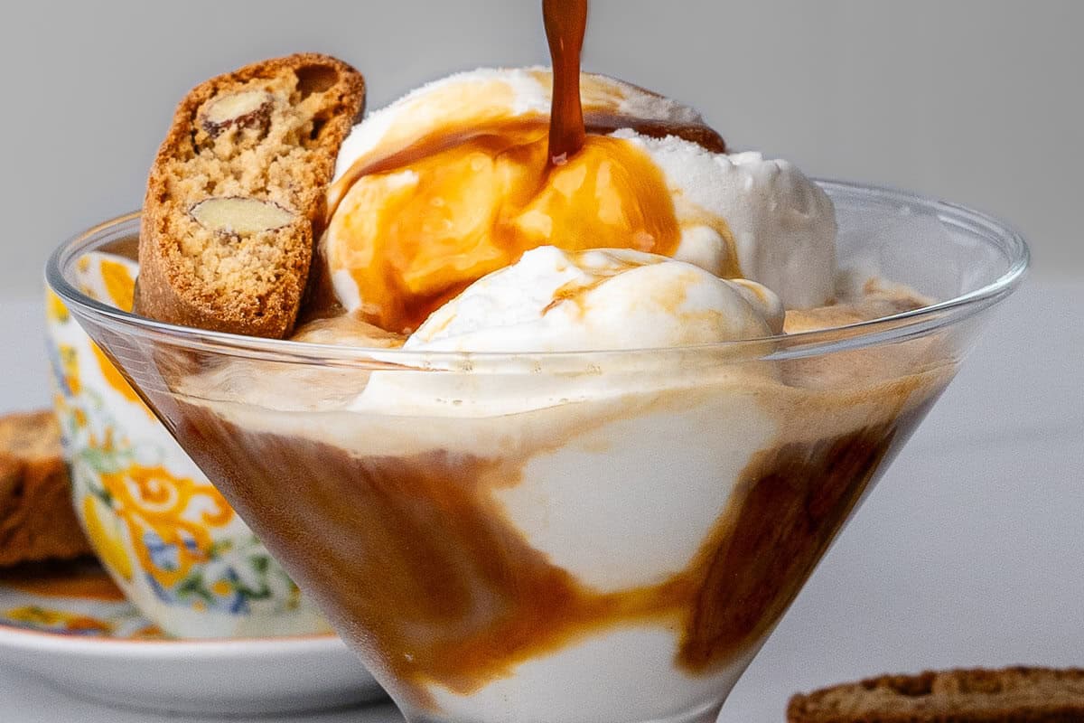 Close up of affogato with coffee being poured onto the vanilla ice cream