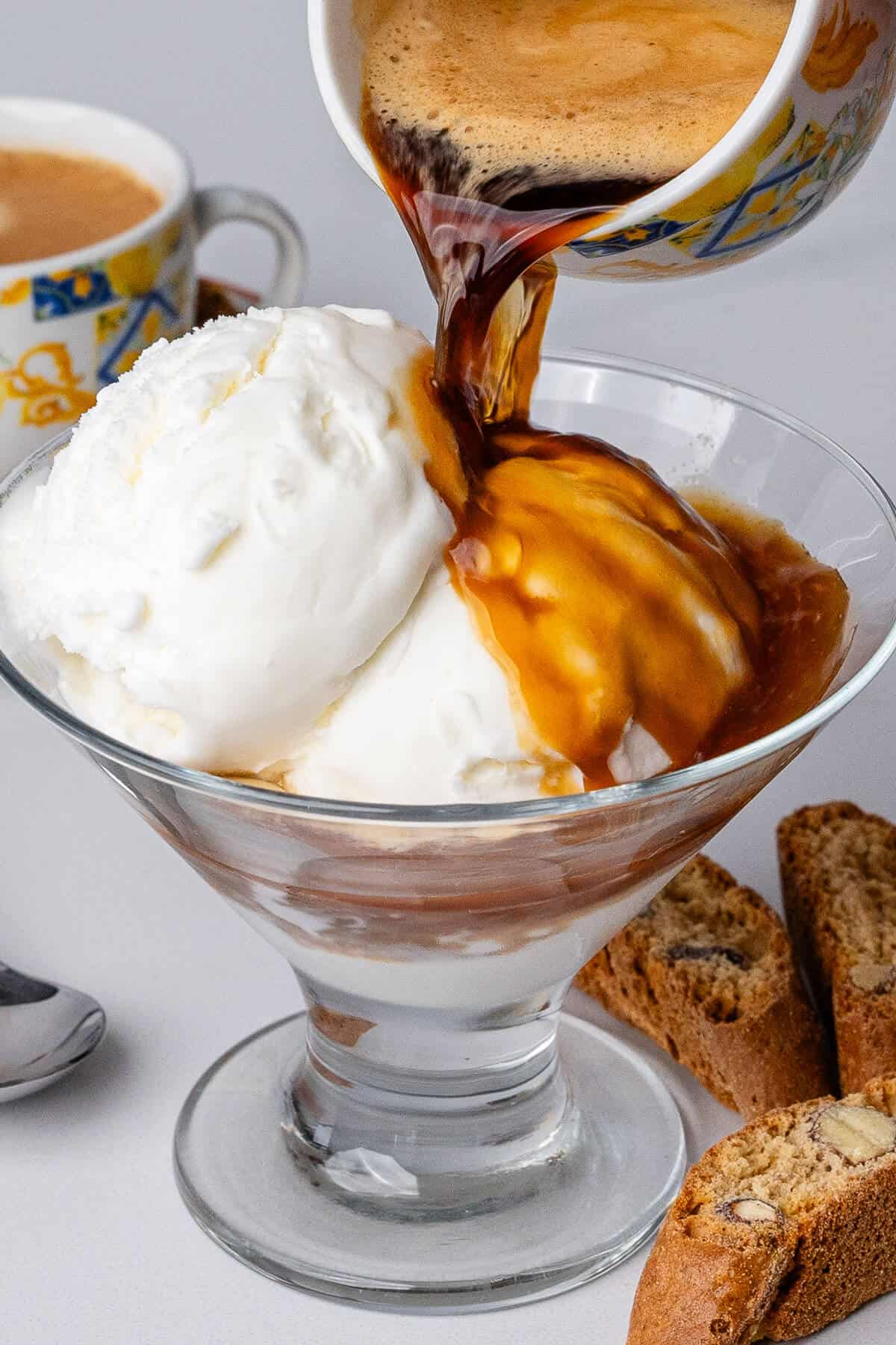 Affogato in a glass with coffee being poured onto the gelato