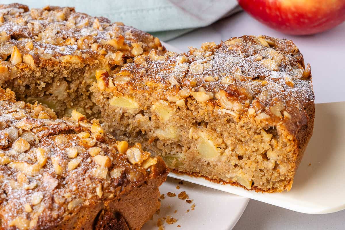 Piece of apple cake coming out and away from the cake