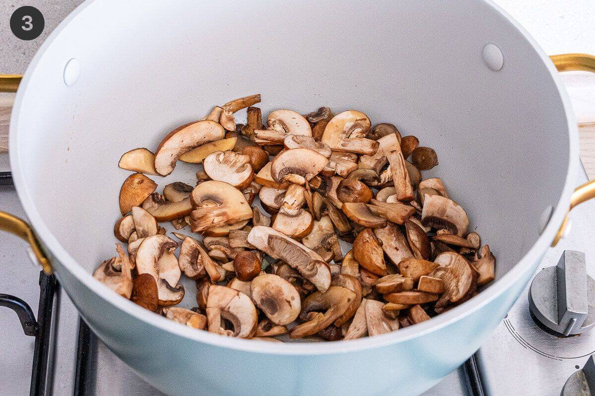 Mushrooms being sautéed in a large pot