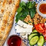 Persian Breakfast served on a plate with barbari bread and tea on the side