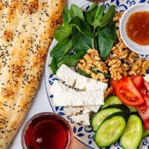 Persian Breakfast served on a plate with barbari bread and tea on the side